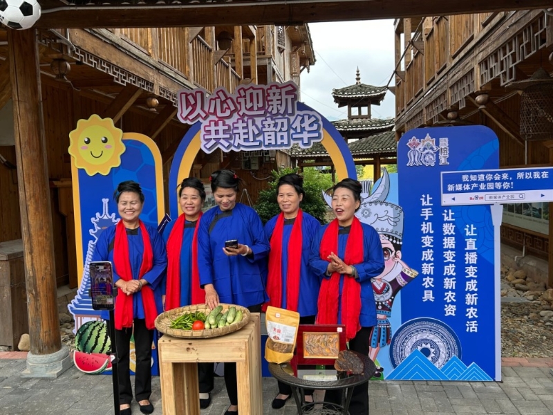 在新媒体产业园，一群穿著侗族服装的中年妇女唱着侗歌直播带货。